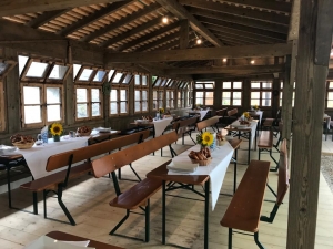 Innenansicht des historischen Pavillons mit gedeckten Biertischen