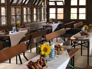 Festlich vorbereitete Sitzplätze mit Sonnenblumen und Brezen