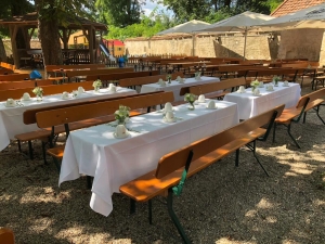Gedeckte Festtafeln im schattigen Biergarten